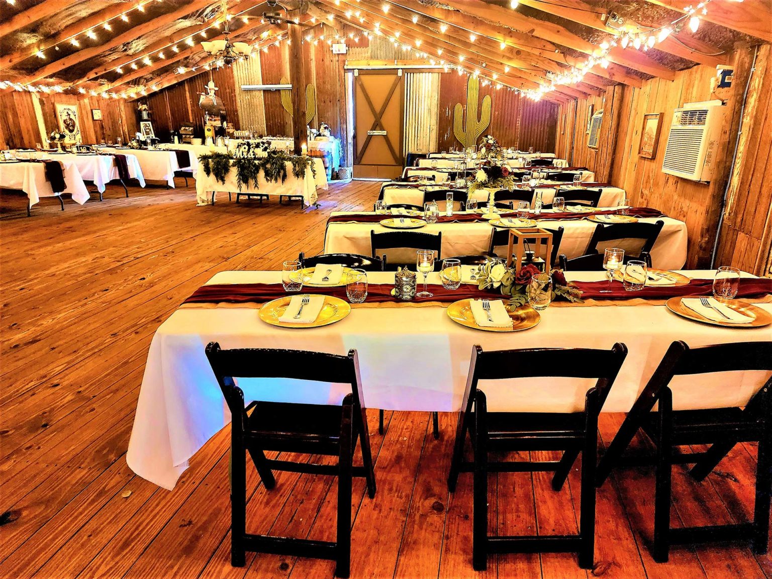 Reception tables arranged inside the Chisholm Trail Rustic Venue barn