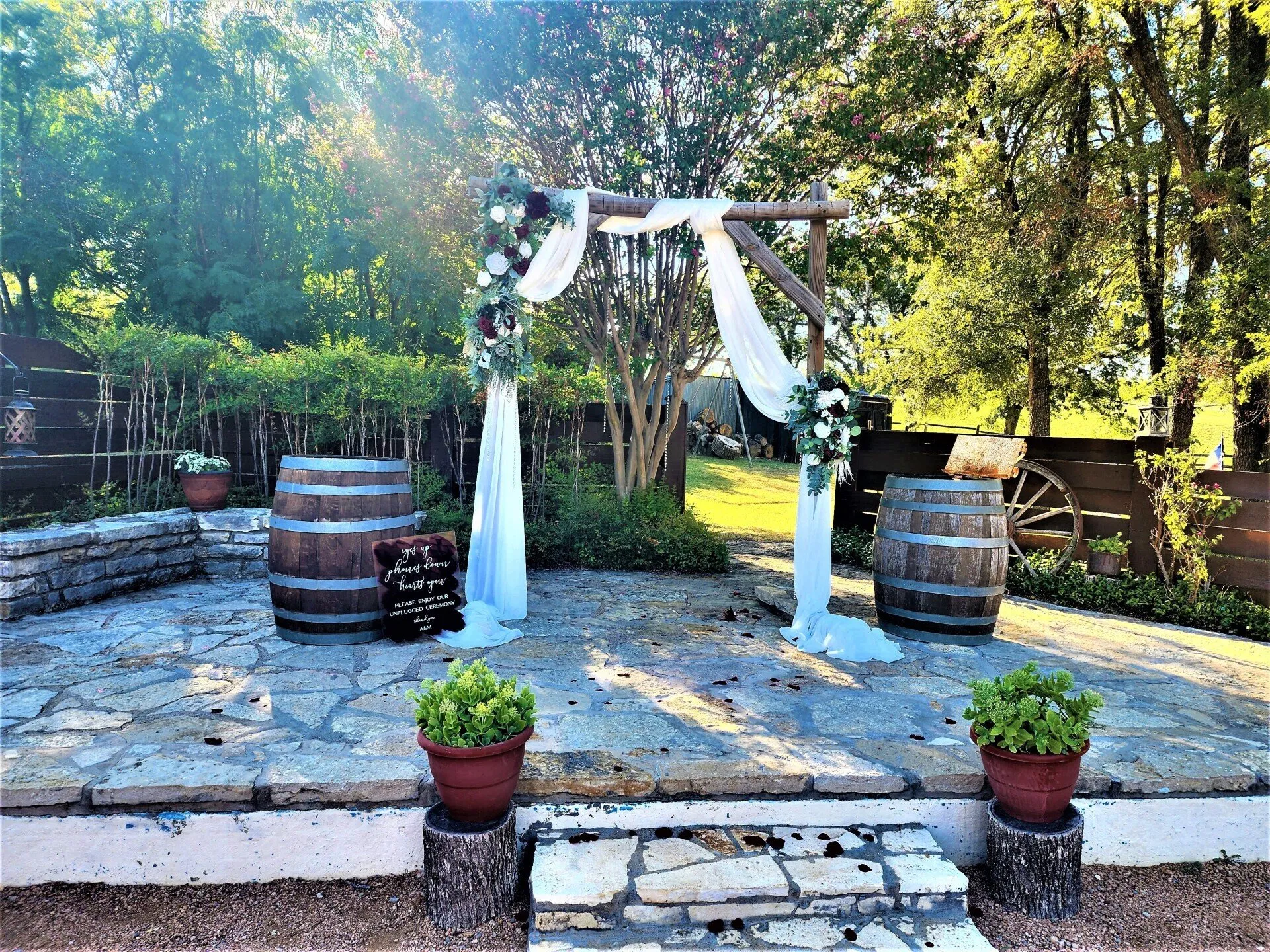 Outdoor ceremony arbor with floral arrangements at Chisholm Trail Rustic Venue