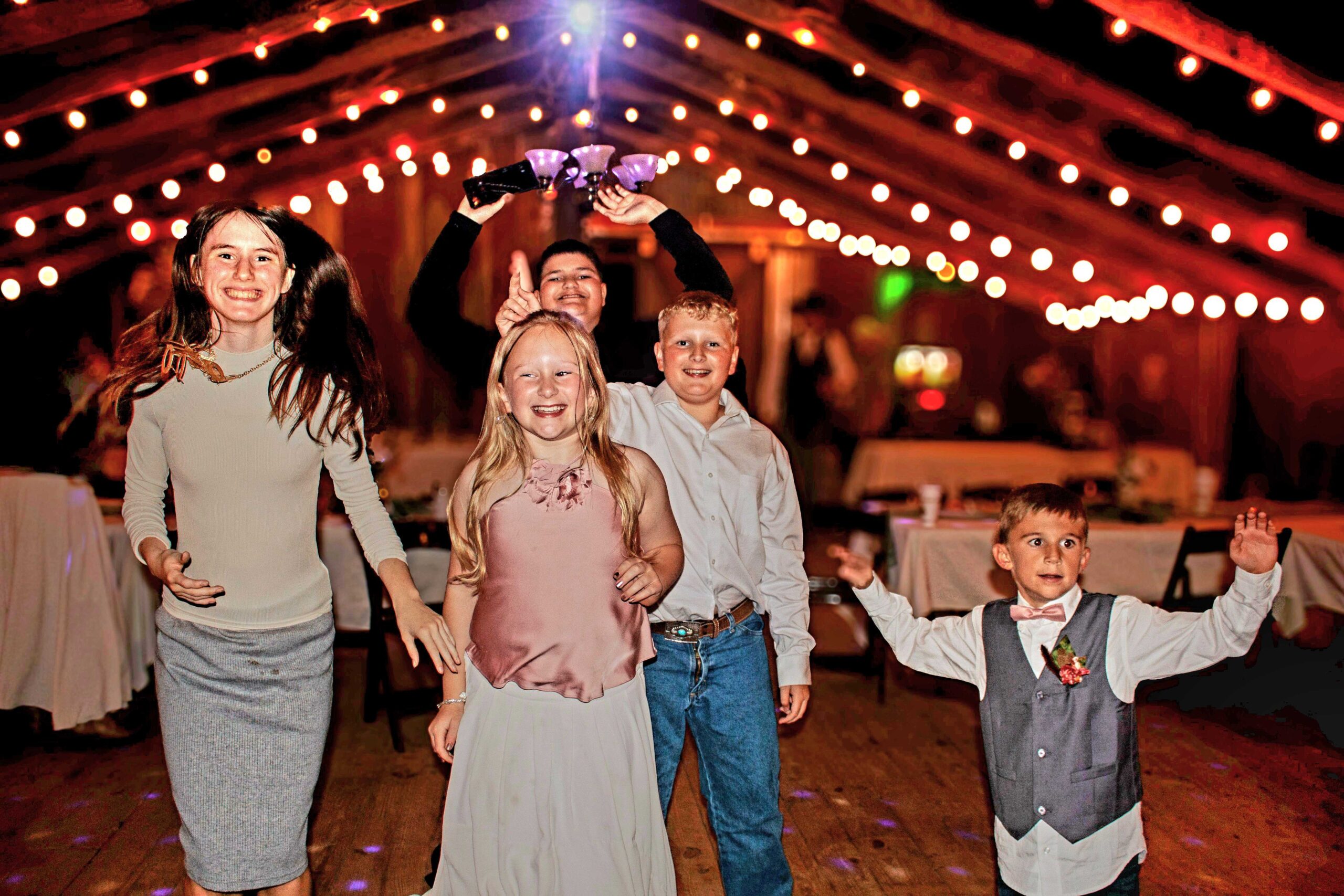 Kids dancing at a celebration inside the barn