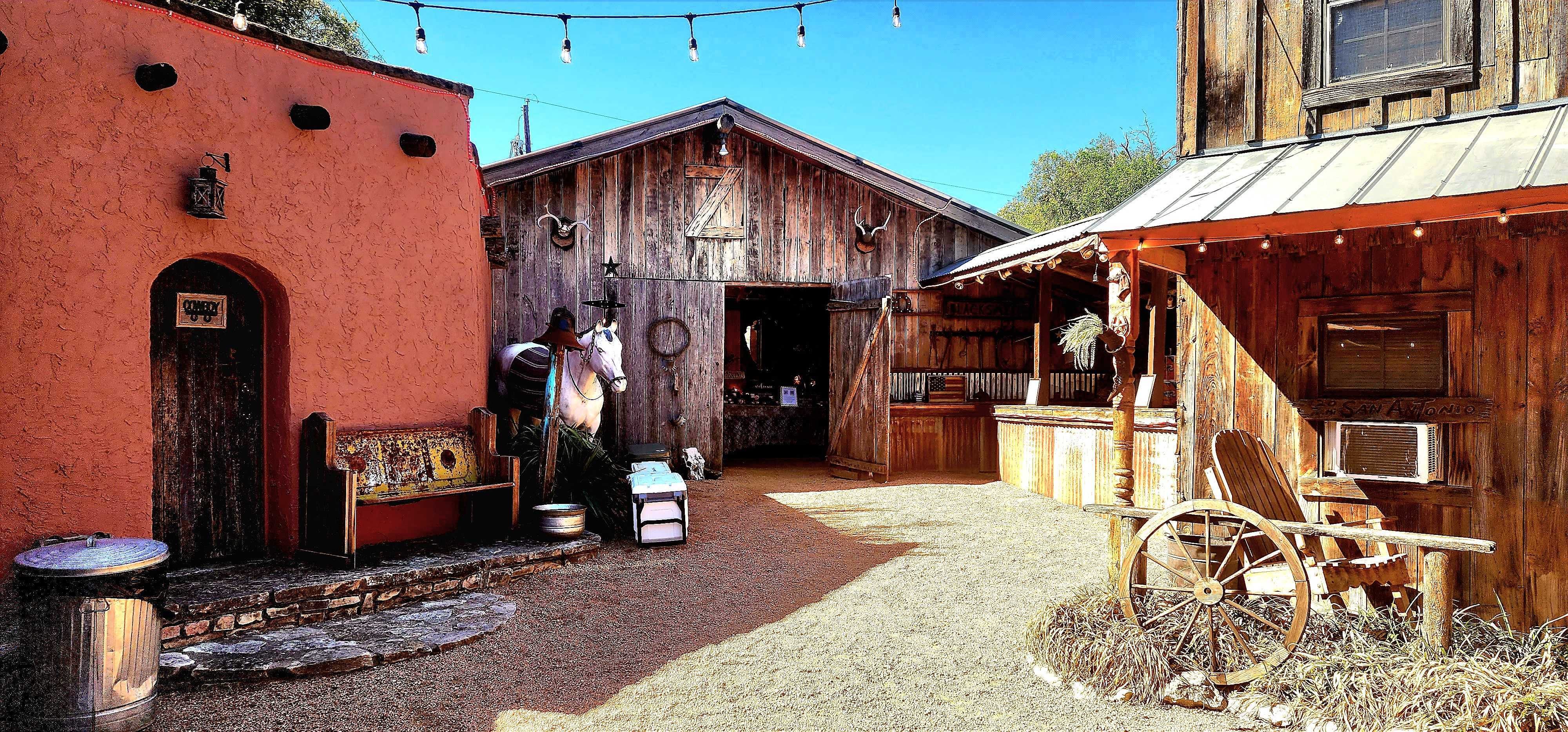 Western town courtyard with saloon and rustic storefronts at Chisholm Trail Rustic Venue