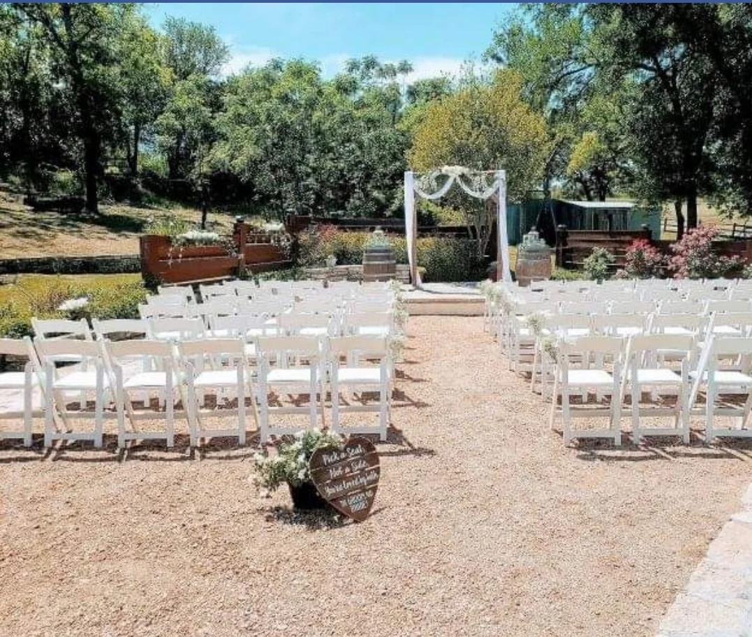 Outdoor ceremony chairs facing the arbor at Chisholm Trail Rustic Venue