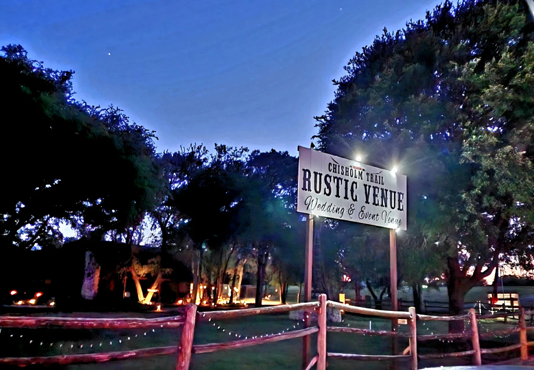 Chisholm Trail Rustic Venue sign lit at night